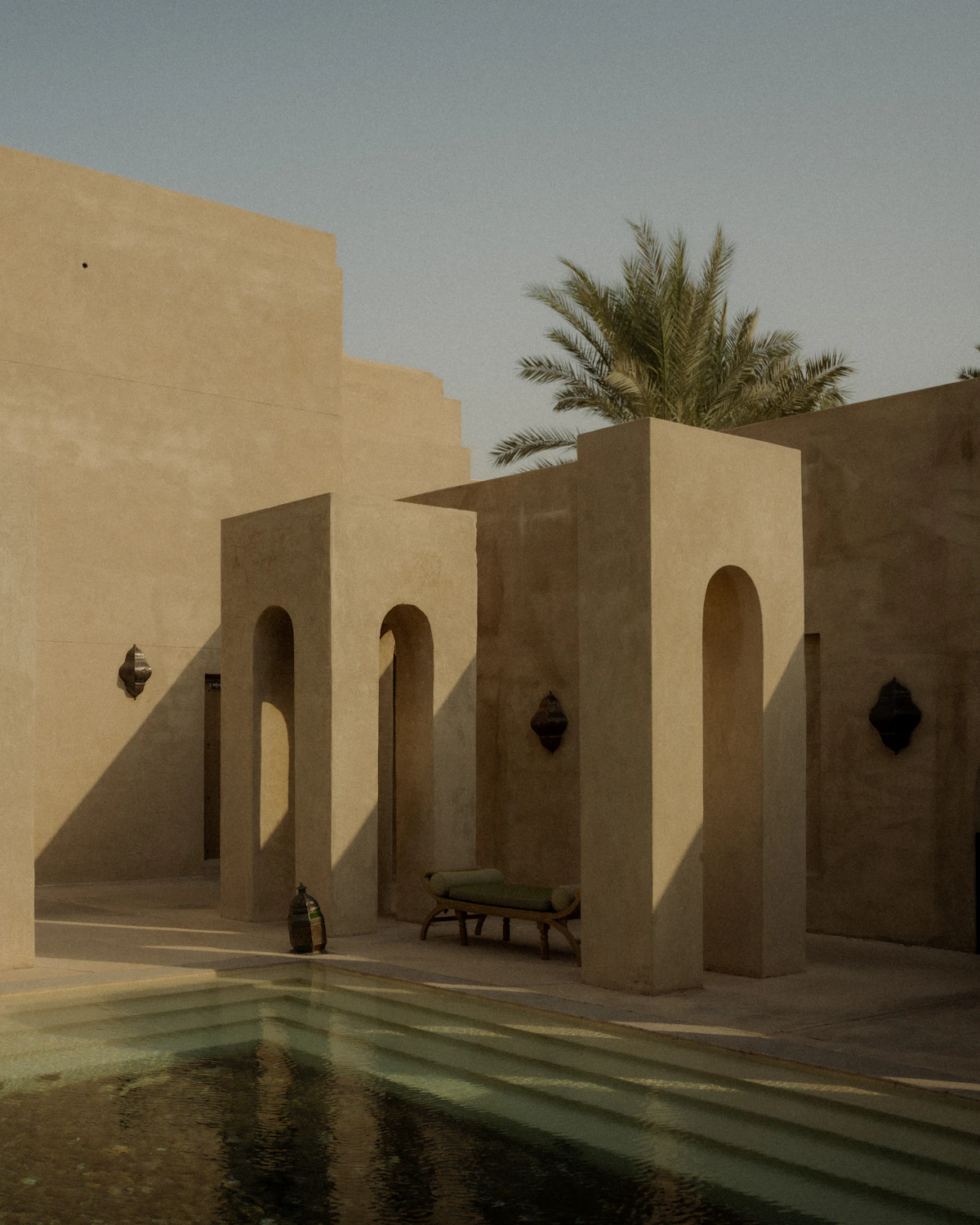 A shaded courtyard with arches and a long table.